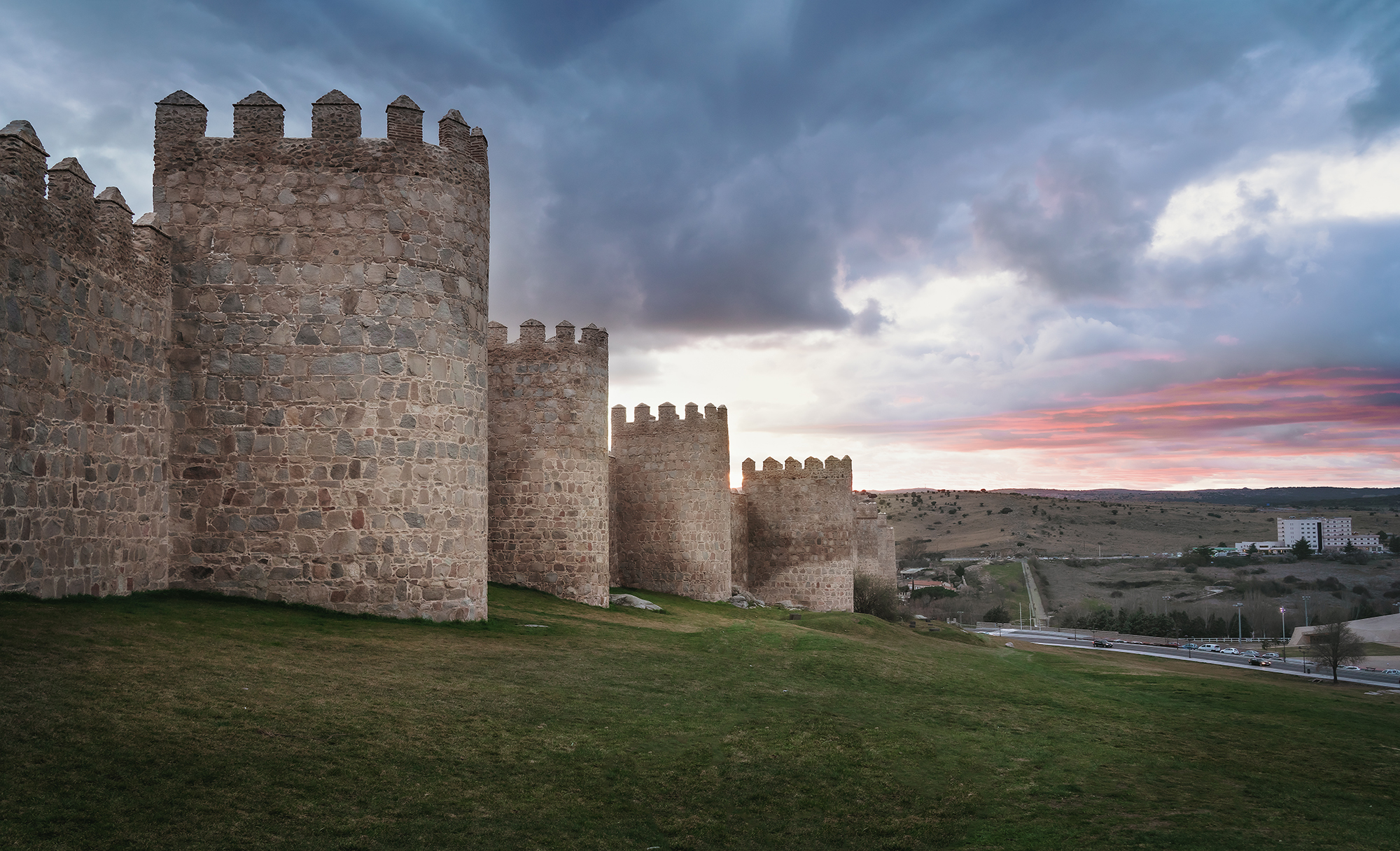 Medieval walls at sunset across the Castilian plateau